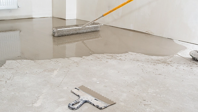 A picture of a paint roller painting a garage floor.