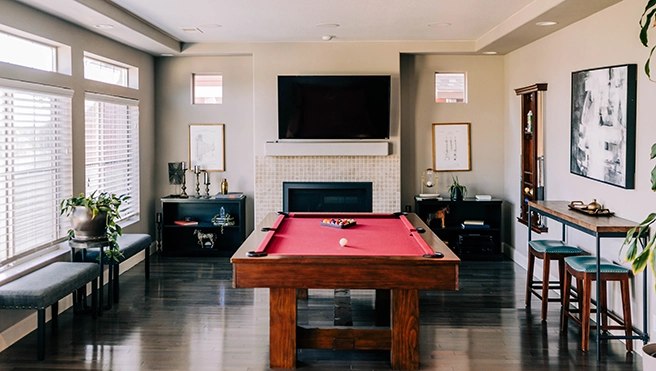 A game room with a fire place and a pool table.