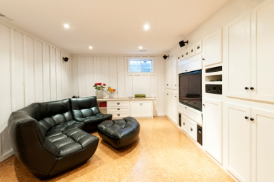 Large Black Sofa in an Open White Basement.