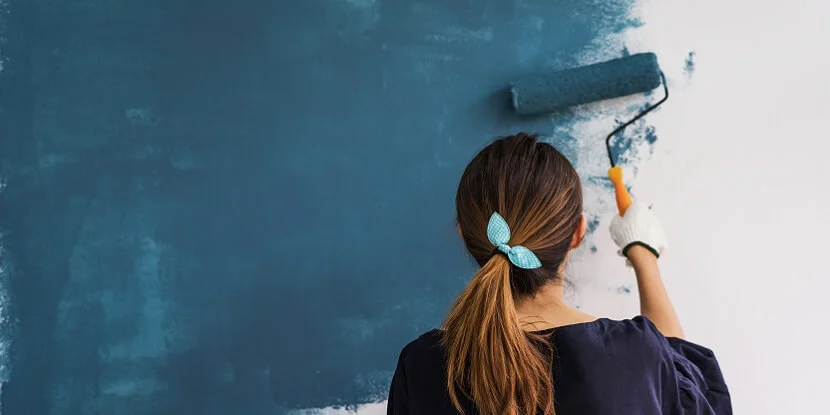 Lady painting wall.